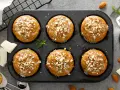 Sześć pysznych muffinek dla dzieci, polanych lukrem i posypanych orzechami, czeka na spróbowanie.