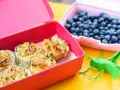 Pyszne przekąski na piknik dla dzieci: muffinki jajeczne z warzywami i borówki. Zabawna koniczynka dodaje humoru!