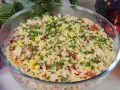 Pyszna sałatka z makaronem orzo, kukurydzą, papryką i kurczakiem, posypana szczypiorkiem. Idealna na letnie dni.