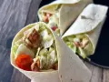 Pyszna tortilla z kurczakiem, sałatą, pomidorkami i sosem. Idealna na szybki lunch.