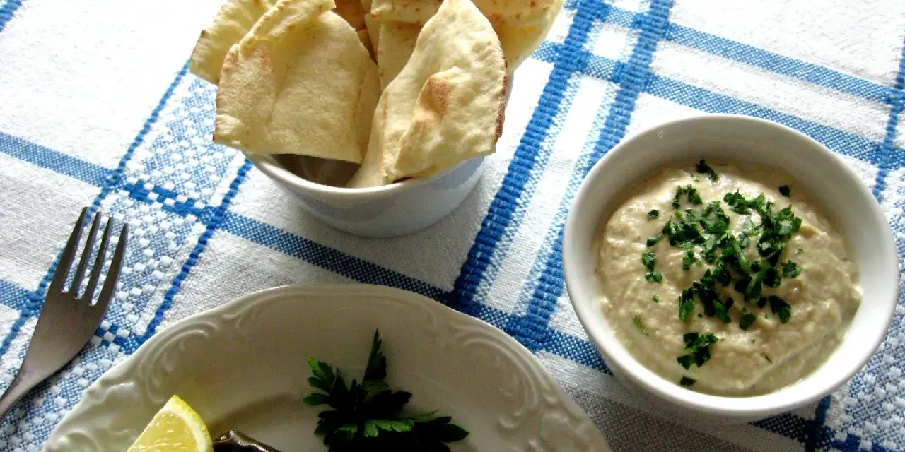 Pyszna pasta z bakłażana z natką pietruszki, podana z pitą i cytryną. Idealna na przekąskę.