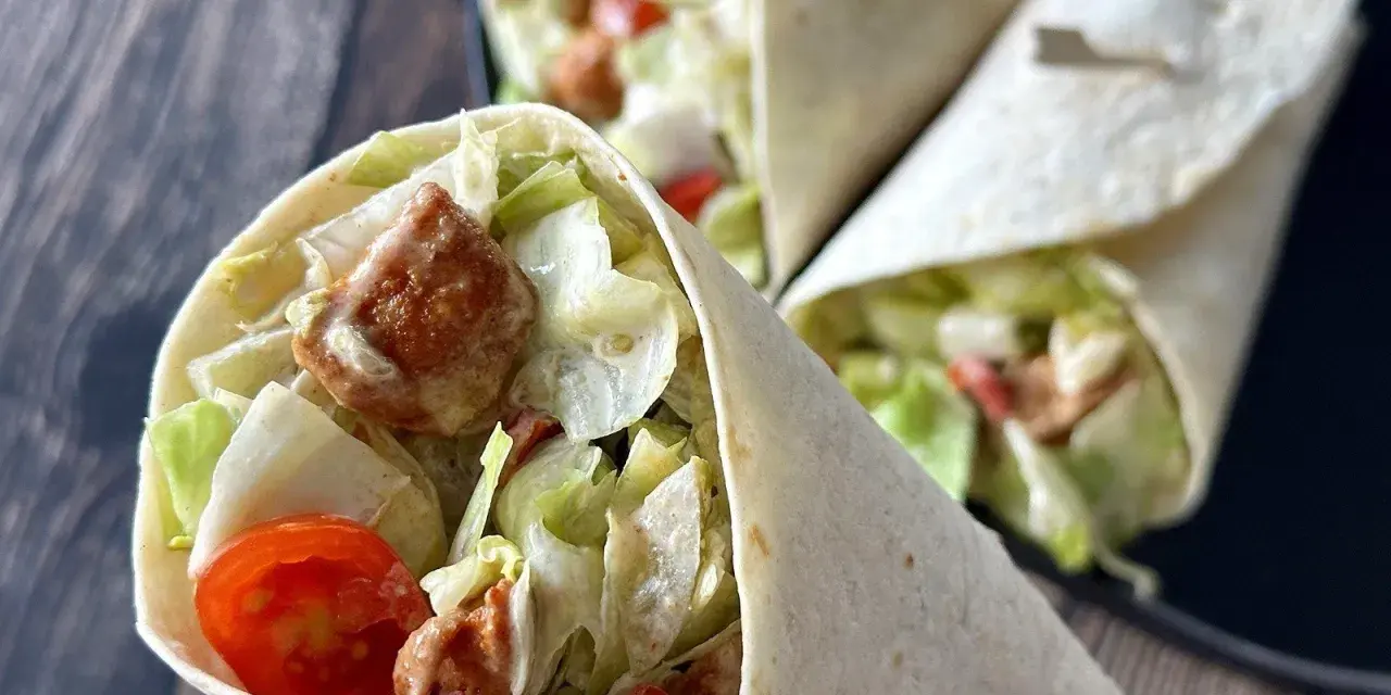 Pyszna tortilla z kurczakiem, sałatą, pomidorkami i sosem. Idealna na szybki lunch.