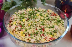 Pyszna sałatka z makaronem orzo, kukurydzą, papryką i kurczakiem, posypana szczypiorkiem. Idealna na letnie dni.